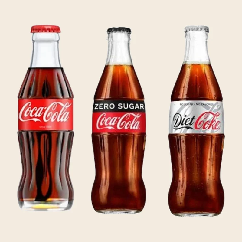 Glass bottles of Coca-Cola, Coke Zero Sugar and Diet Coke side by side