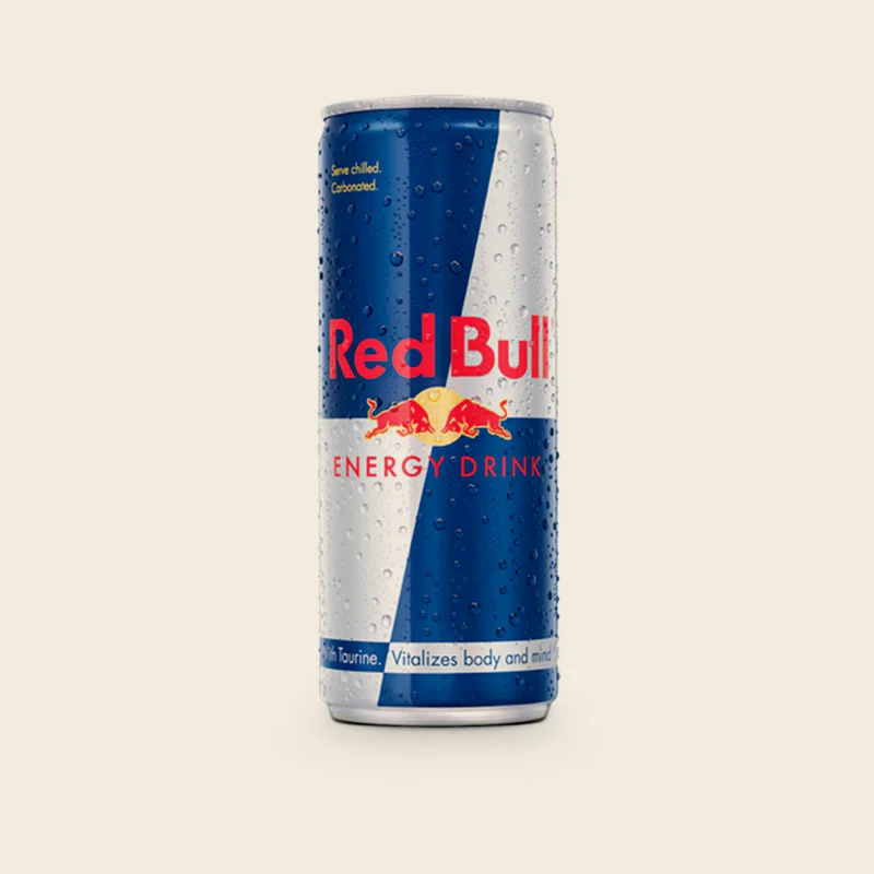 A chilled can of Red Bull on a dark table